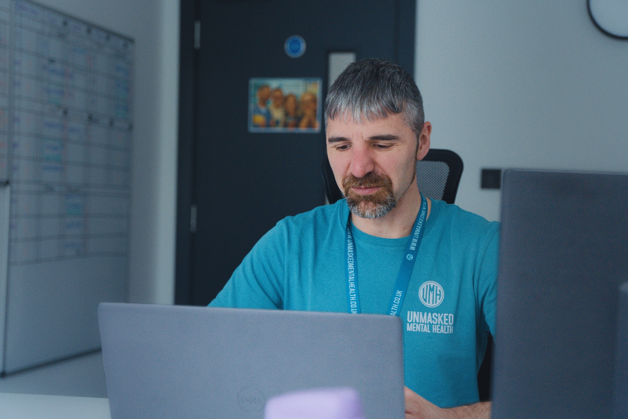 An Unmasked counsellor working at a desk in the Halifax offices
