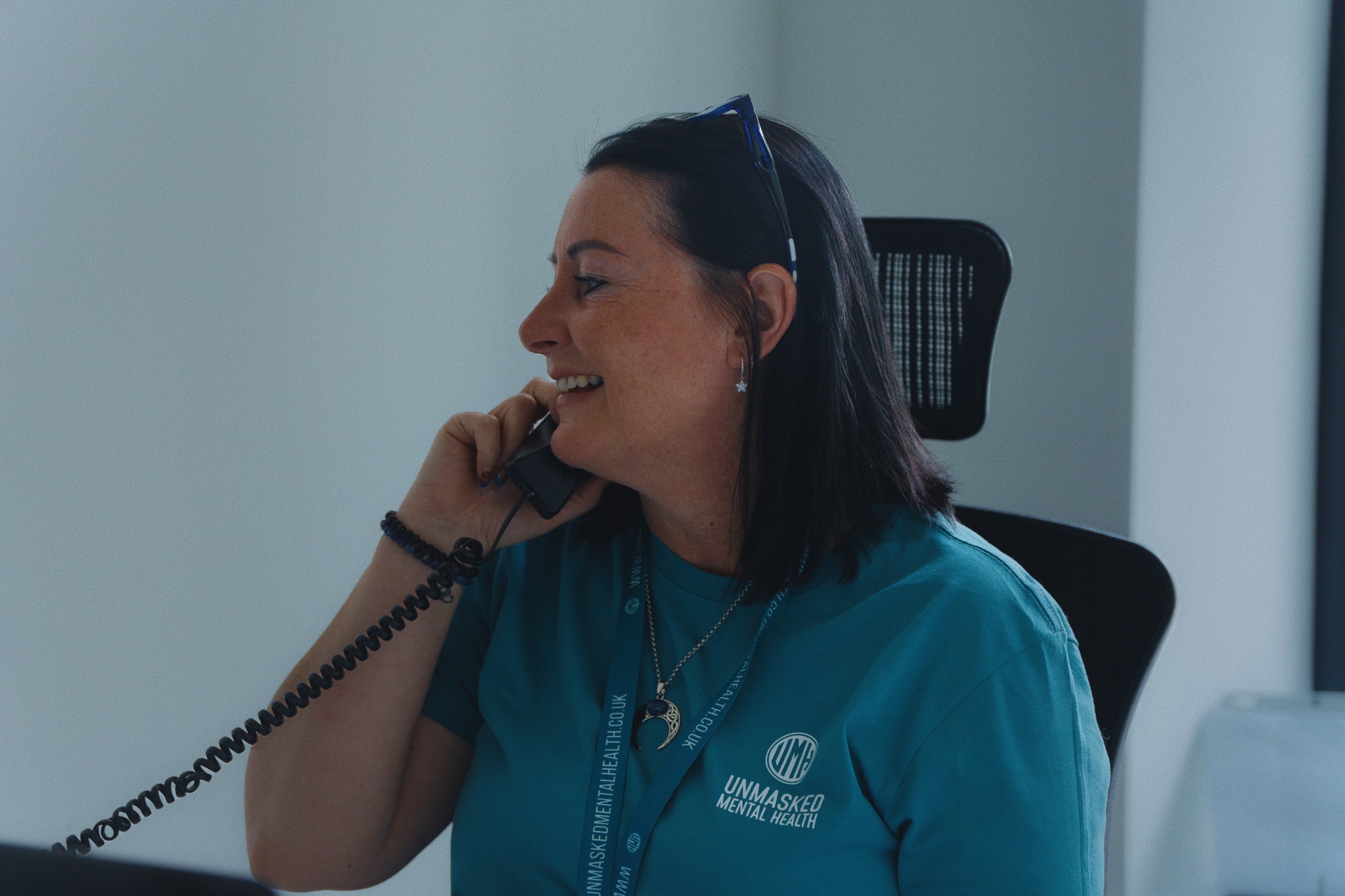 An Unmasked team member taking a support call in branded clothing