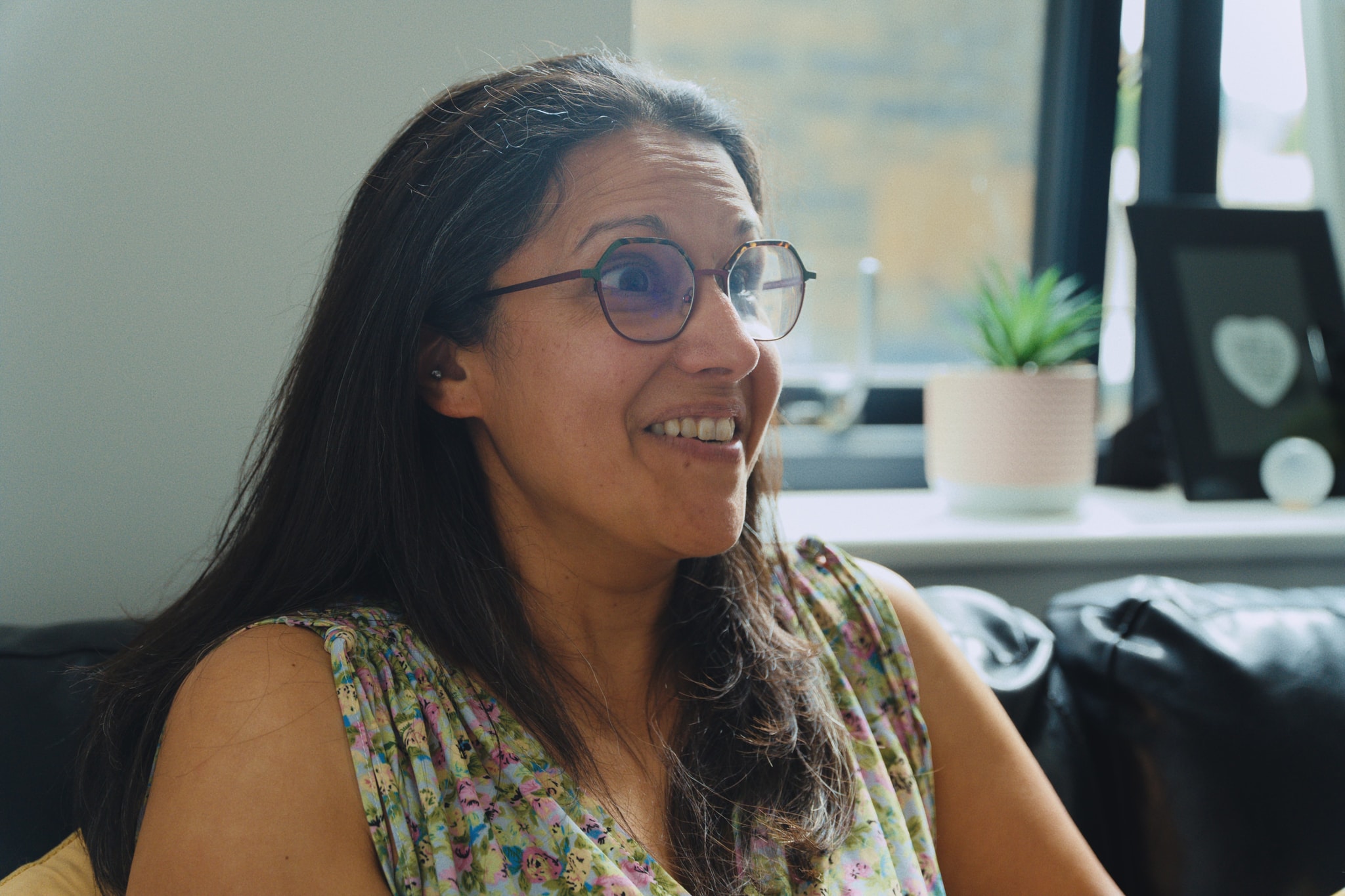 A woman smiling calmly while seated in an Unmasked counselling room